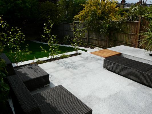 The dark contrasting outdoor furniture looks very stylish against the sleek Bradstone Natural Granite in Silver Grey.
