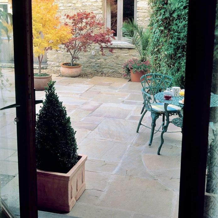 Bradstone Natural Sandstone Sunset Buff Mixed Size Patio Pack Paving creating a lovely outdoor eating area